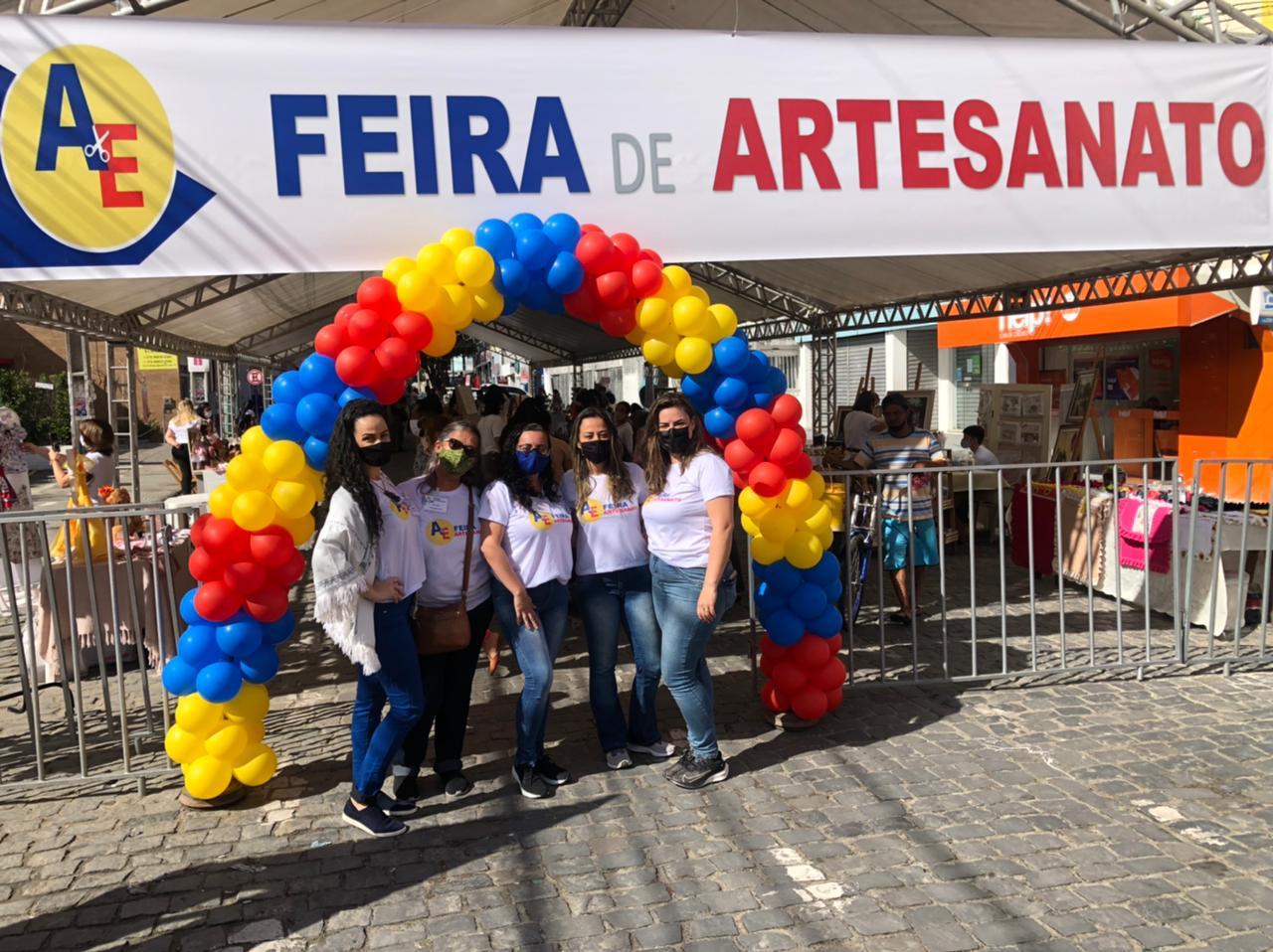 Equipe de organização em frente à feira, no centro da cidade